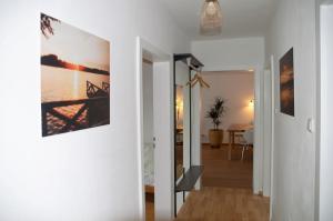 Ferienwohnung Seenglück في فاكيرسدورف: ممر يؤدي إلى غرفة معيشة مع لوحة على الحائط
