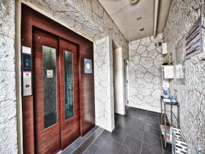a hallway with a wooden door in a building at Terrace Resort Shintoshin in Naha