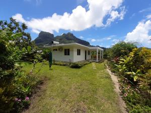 a white house with a mountain in the background at Fare o'Eden in Bora Bora