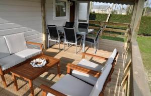 un patio con sillas, una mesa y una mesa con sillas en Northseachalets Ameland en Buren