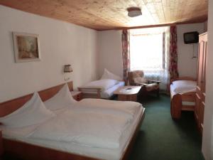 ein Schlafzimmer mit einem Bett, einem Sofa und einem Stuhl in der Unterkunft Weisses Rössl Werfen in Werfen