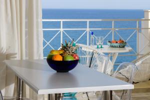 eine Schale mit Obst auf einem weißen Tisch in einem Zimmer in der Unterkunft Bellevue Suites in Agios Nikolaos