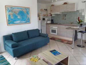 a living room with a blue couch and a kitchen at Fare o'Eden in Bora Bora