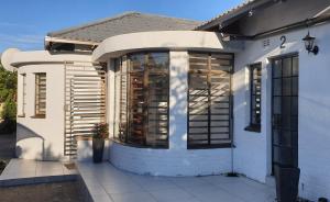 a white house with a large window on it at Casa Mo Boutique Guest House in Bloemfontein