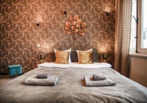una camera da letto con un grande letto con due cuscini sopra di Luxury Suits Historic Center ad Anversa