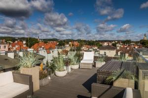 a balcony with chairs and plants on a roof at Sky and Sea by Renters Prestige in Sopot