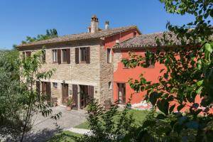 una gran casa de ladrillo rojo con patio en Agriturismo L'Esinante, en Cupramontana