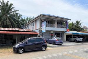 a couple of cars parked in front of a building at OYO 90205 Bayu Sintok Motel in Changlun