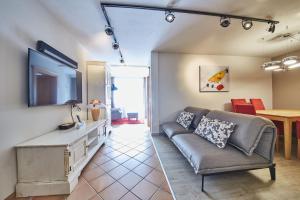 een woonkamer met een bank en een televisie bij Boutique Appartements in Saalbach Hinterglemm