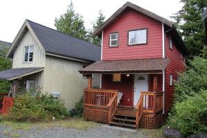 ein rotes und weißes Haus mit einer Veranda in der Unterkunft Cozy 2 Bedroom Waterfront Cottage With Hot Tub! in Ucluelet