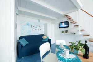 ein Wohnzimmer mit einem blauen Sofa und einer Treppe in der Unterkunft Alfieri Rooms - Amalfi coast in Atrani