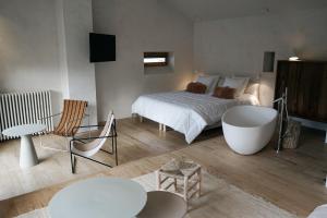 ein Schlafzimmer mit einem Bett und einer Badewanne in einem Zimmer in der Unterkunft La Maison des Sources in Angoulême