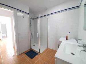a white bathroom with a shower and a sink at Costa Mathilda Suite in Los Pocillos +35 photos