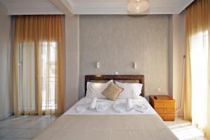 una camera da letto con letto, lenzuola e cuscini bianchi di PortoDream Studios & Apartments a Néos Marmarás