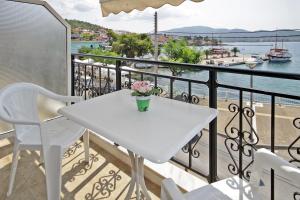 a white table on a balcony with a view of the water at PortoDream Studios & Apartments in Neos Marmaras