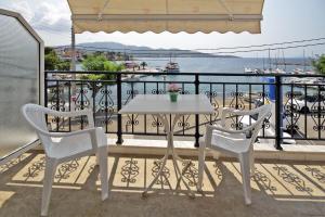 un tavolo bianco e 2 sedie sul balcone di PortoDream Studios & Apartments a Néos Marmarás