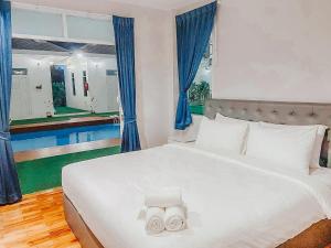 a bedroom with a bed with two towels on it at Bianco House Resort in Cha Am