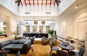a living room with a couch and chairs and a piano at Hotel Imperial - Liburnia in Opatija