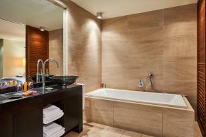 a bathroom with a tub and a sink at DO&CO Hotel Vienna in Vienna