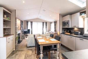 cocina y sala de estar con mesa en una habitación en Hidden Jewel Lodge with Hot Tub en York