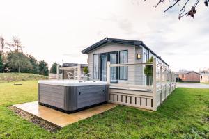 a tiny house with a hot tub in a yard at Hidden Jewel Lodge with Hot Tub in York