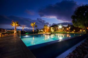 una piscina por la noche con una casa en el fondo en Stavros Beachfront Homeleader, en Stavros