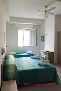 een slaapkamer met 2 bedden en groene lakens bij Hotel Ritter in Cattolica