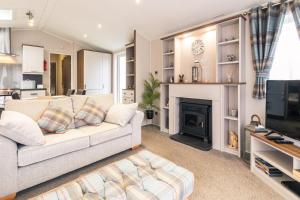 sala de estar con sofá y chimenea en Hidden Jewel Lodge with Hot Tub en York