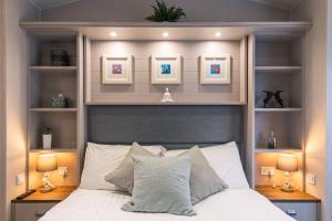1 dormitorio con 1 cama con 2 lámparas y fotografías en Hidden Jewel Lodge with Hot Tub en York