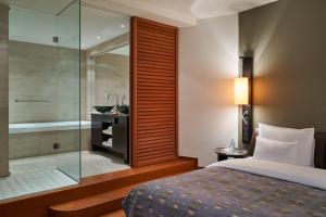 a bedroom with a shower and a bed and a bathroom at DO&CO Hotel Vienna in Vienna