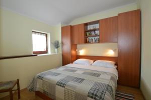 sypialnia z łóżkiem i półką na książki w obiekcie Apartment Jasmina w miejscowości Mali Lošinj