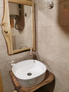 W łazience znajduje się biała umywalka i lustro. w obiekcie Brvnare Sekulic w mieście Sekulić 
