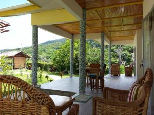 a patio area with chairs, tables and umbrellas at Zanboza Guesthouse in La Digue