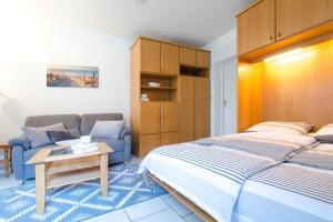 a bedroom with a bed and a couch at App-1-Alkersum in St. Peter-Ording