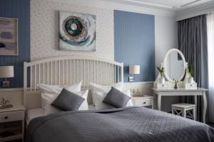 1 dormitorio con 1 cama con paredes azules y espejo en Garni Hotel & Appartements Nordstrand, en Nordstrand