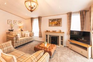 a living room with couches and a television and a fireplace at Hemingway Lodge with Hot Tub in York