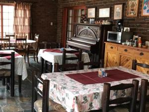 una sala da pranzo con tavolo e pianoforte di Kwela Bed & Breakfast ad Aliwal North
