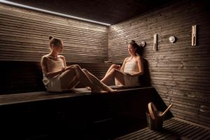 two women sitting on a bench in a room at Hotel Imperial - Liburnia in Opatija