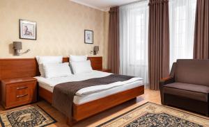 ein Hotelzimmer mit einem Bett und einem Stuhl in der Unterkunft Villa Marta in Truskawez