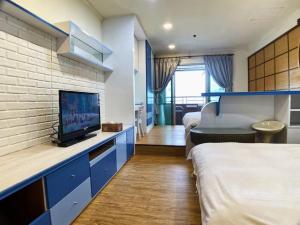 um quarto de hotel com uma cama e uma televisão em MB Hotel em Kaohsiung