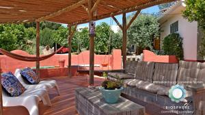 a patio with a couch and chairs and a hammock at Quinta das Cantigas by Book YourHoliday PT in Aljubarrota