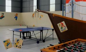 a ping pong table in a room with bottles of beer at Quinta das Cantigas by Book YourHoliday PT in Aljubarrota +18 photos