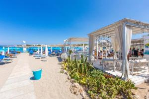 a beach with chairs and people on the beach at Villa Salento in Torre Santa Sabina