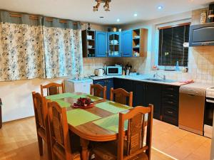 a kitchen with a wooden table and a kitchen with blue cabinets at Chalupa ŠŠ in Vlachy