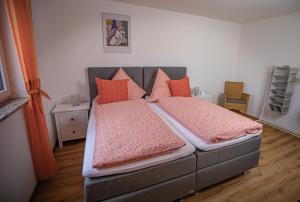um quarto com uma cama com almofadas cor-de-rosa e laranja em Apartment Haus Maria Waldblick em Burtenbach