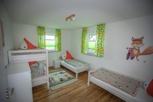 a small room with two beds and a crib at Apartment Haus Maria Waldblick in Burtenbach +72 photos