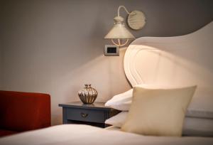 a bedroom with a bed and a lamp on a table at Hotel Lungomare Opatija - Liburnia in Opatija