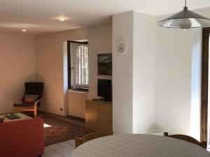 a living room with a table and a tv in it at Appartamento Vadaione Est in Giustino