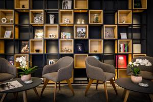 a room with chairs and a book shelf at Hotel Lungomare Opatija - Liburnia in Opatija