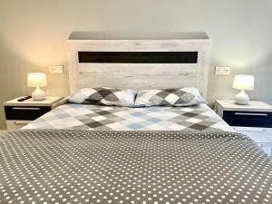 ein Bett mit einer schwarz-weißen karierten Decke in der Unterkunft Apartamentos Aranda - La Villa in Aranda de Duero